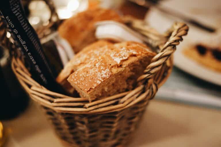 Basket of crusty bread on a restaurant table in warm low light