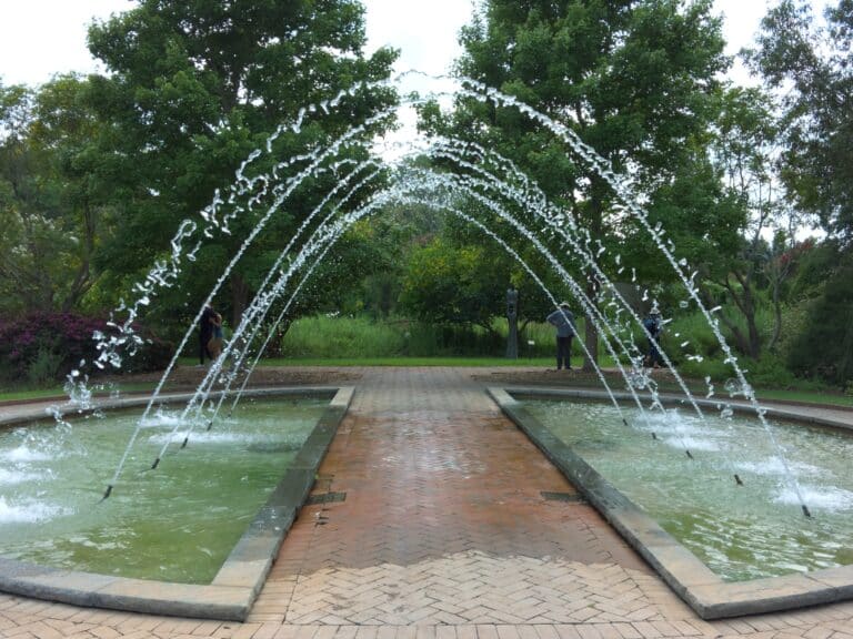 Arching water jets over the brick canal walk in the formal gardens at Daniel Stowe Botanical Garden near Lake Wylie