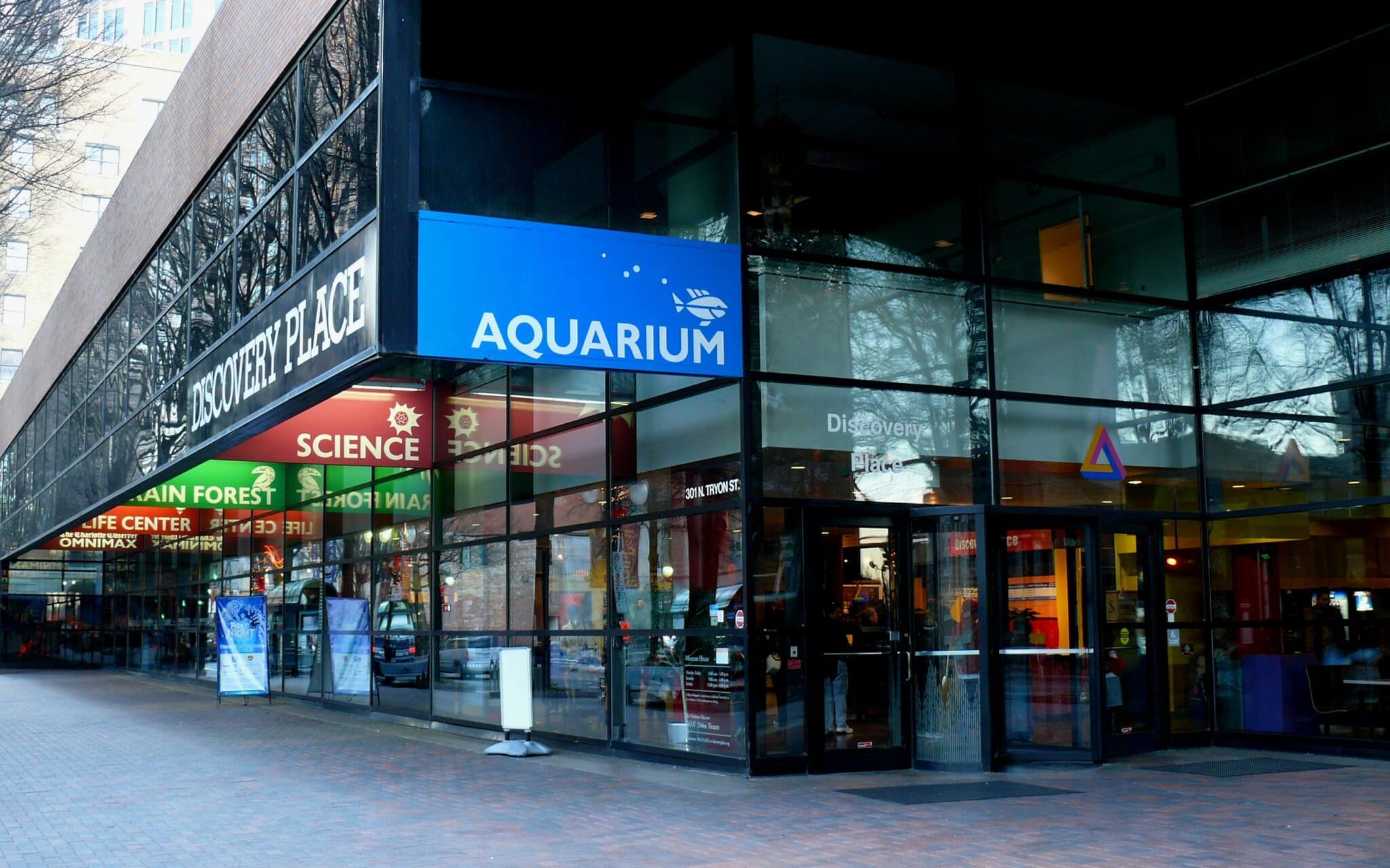 The glass corner entrance of Discovery Place Science on North Tryon Street in Uptown Charlotte