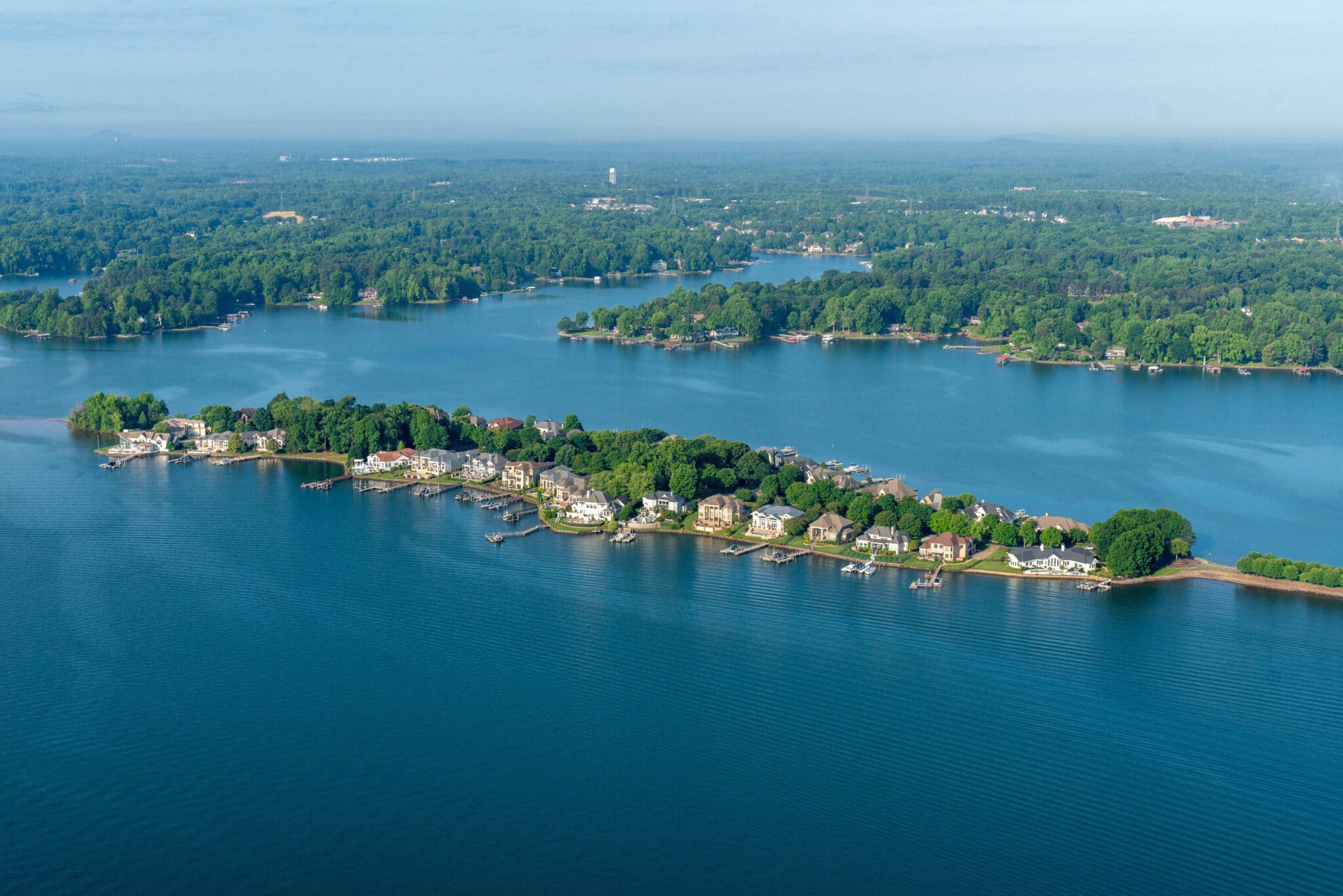Aerial view of Lake Norman in North Carolina with blue water, wooded shoreline and lakefront homes with private docks