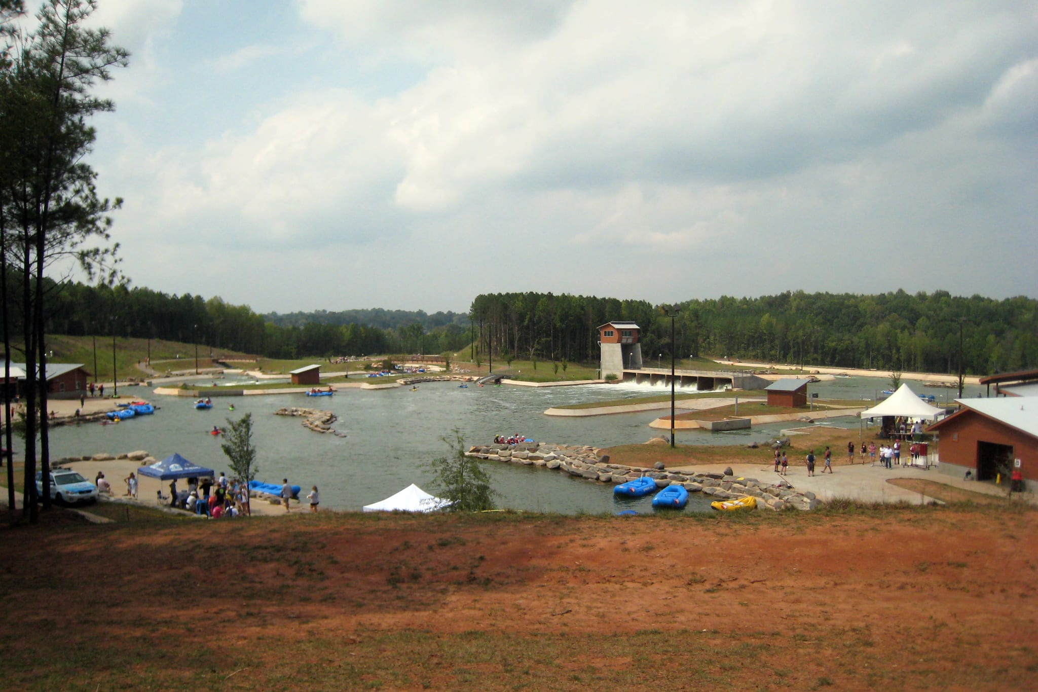 Rafts on the whitewater rapids course at the U.S. National Whitewater Center in Charlotte, surrounded by pine woodland